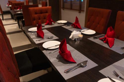 a long table with red napkins and red bows on it at Visa Karena Hotels in Port Harcourt