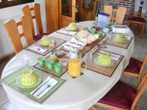 una mesa con un juego de mesa con comida y zumo de naranja en Au fil de l'Eau, en Saulzoir