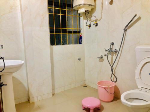 a bathroom with a shower and a toilet and a sink at Pine Hill Home Stay in Shillong