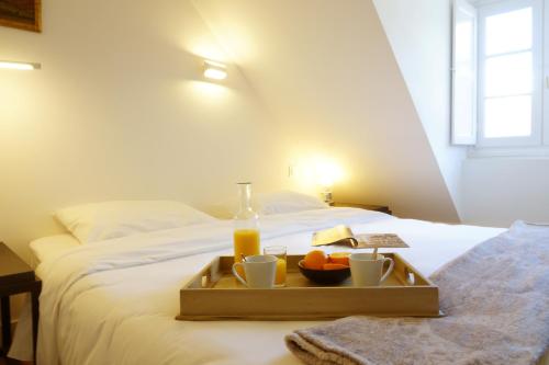 - un plateau de nourriture sur un lit avec une bouteille de jus d'orange dans l'établissement Maison Eugénie, à Luchon