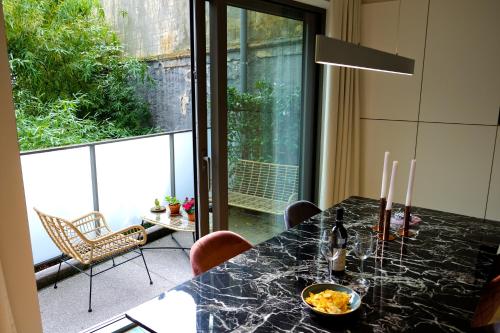 uma sala de jantar com uma mesa com cadeiras e uma janela em Modern Appartment in the Heart of Ghent em Gent