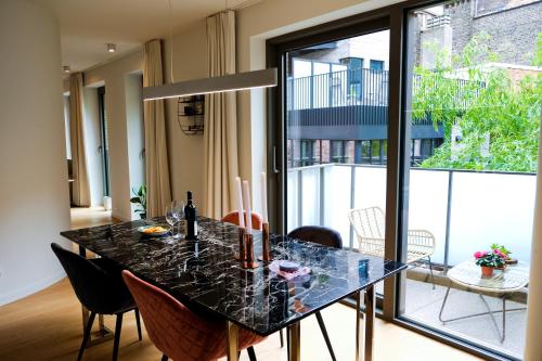 a dining room with a black table and chairs at Modern Appartment in the Heart of Ghent in Ghent