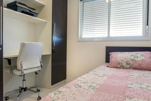 FLAT SAINT TROPEZ في فلوريانوبوليس: غرفة نوم بسرير ومكتب وكرسي