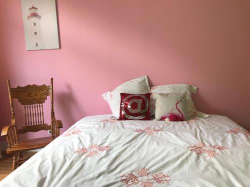 - une chambre avec un lit doté de draps blancs et d'une chaise dans l'établissement Villa Sainte Rosalie, à Wimereux