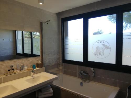 a bathroom with a sink and a large window at Hôtel Saint Roch in Martigues