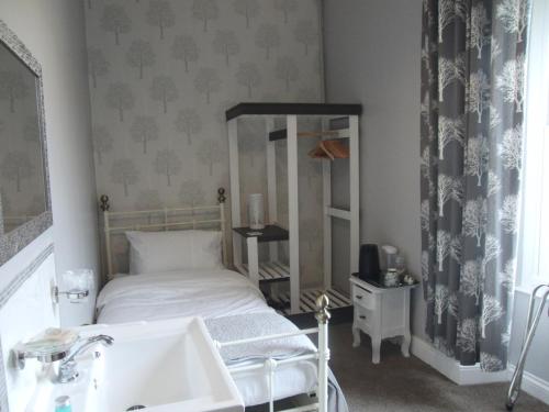 a bedroom with a bed and a sink in it at Llanwrtyd Hall B&B Angelis Holistic Retreat in Llanwrtyd Wells