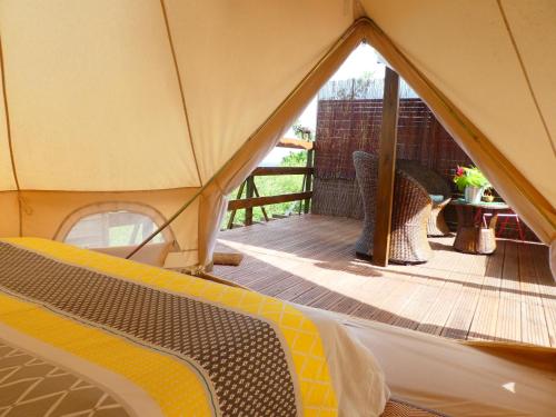 Cette tente dispose d'une terrasse en bois avec une table et une table. dans l'établissement Kawaida - Hébergement insolite - Glamping Makazi, à Sainte-Luce