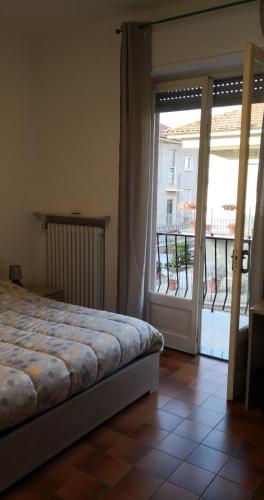 a bedroom with a bed and a door to a balcony at Casa della Sala Spada in Casale Monferrato