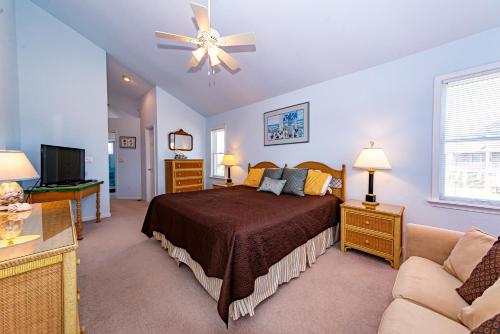 a bedroom with a bed and a couch at Swink Cottage in Southern Shores
