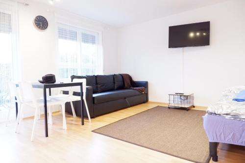 a living room with a couch and a table at Outletcity Apartment Ferienwohnung Metzingen in Metzingen