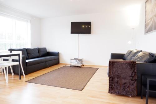 a living room with a couch and a table at Outletcity Apartment Ferienwohnung Metzingen in Metzingen