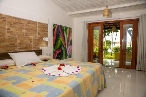 a bedroom with a bed with two towels on it at Hotel Marinas in Pipa