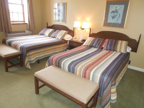 una camera d'albergo con due letti e una sedia di Bridges Guest Quarters ad Abbottstown
