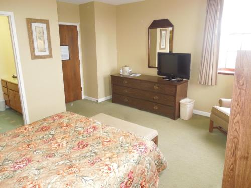 a bedroom with a bed and a dresser with a television at Bridges Guest Quarters in Abbottstown
