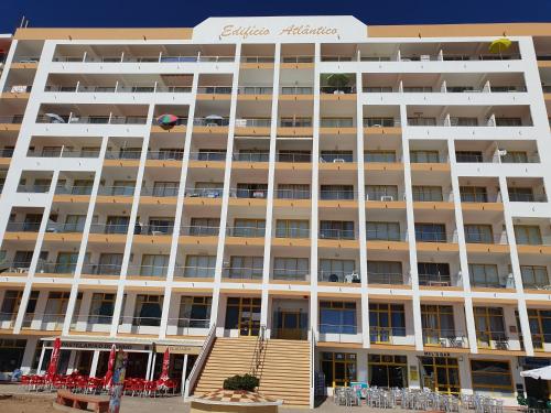 a large white building with stairs in front of it at Apartamento Atlantico - Vista Mar in Monte Gordo