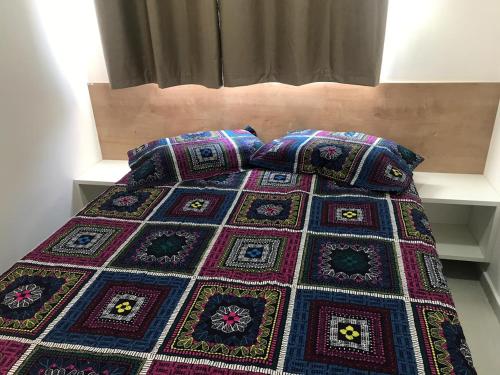 a bed with a blanket and two pillows on it at Praia do Frances in Praia do Frances