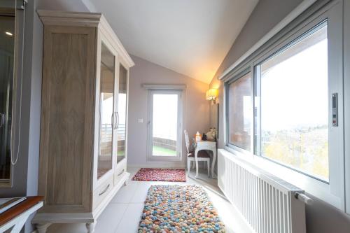 a hallway with a large window and a rug at Urban Faqra Hotel in Kfardebian