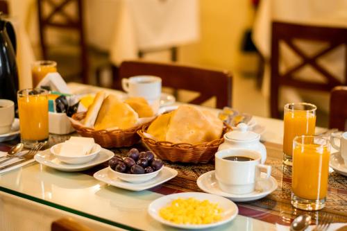a table with a breakfast of bread and coffee and orange juice at Villa Sillar in Arequipa