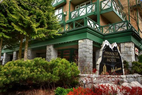 a green building with a sign in front of it at Pinnacle Hotel Whistler in Whistler