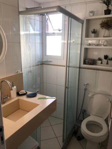 a bathroom with a toilet and a glass shower at Apartamento Iracema Fortaleza in Fortaleza