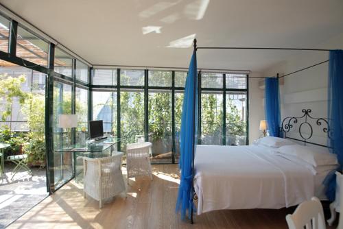 a bedroom with a bed with blue curtains and a desk at Antica Locanda Dei Mercanti in Milan