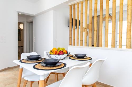 a white dining room with a white table and chairs at Harmony Luxury Villas Naxos in Naxos Chora
