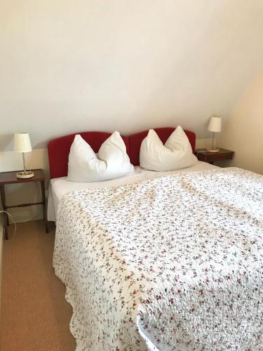a bedroom with a large bed with white pillows at Ferienwohnung Spatzennest in Prerow