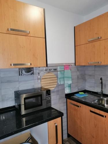 a kitchen with a microwave and a sink at Apartman EDEN No 1 in Teslić
