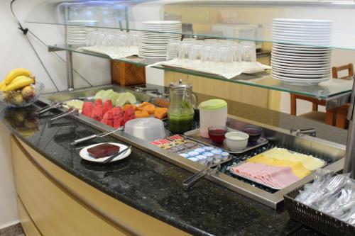 a breakfast buffet in a hotel room with food at Ônix Hotel in Assis