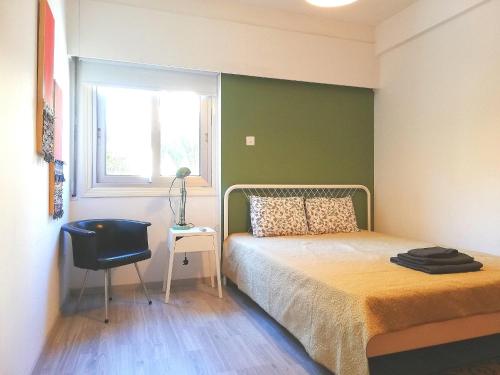 1 dormitorio con cama, ventana y silla en Markora Central Apartment, en Nicosia