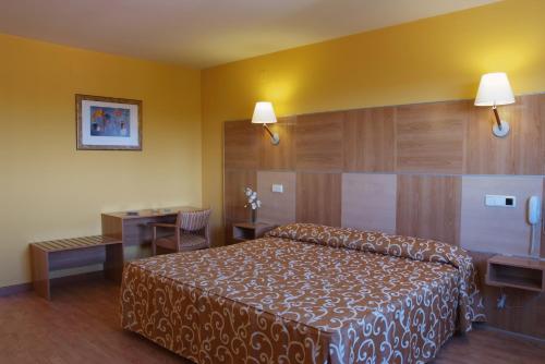 Horcheにあるラ カニャーダのベッドとデスクが備わるホテルルームです。