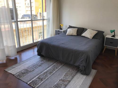 ein Schlafzimmer mit einem Bett und einem großen Fenster in der Unterkunft Depto centrico, 90 m2, 2 habitaciones in Rosario