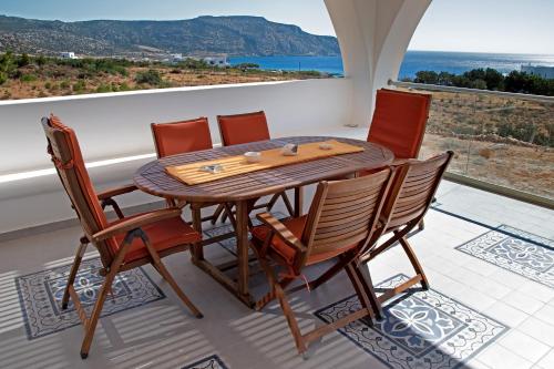 a wooden table and chairs on a balcony at Aelia Luxury Villa in Amoopi
