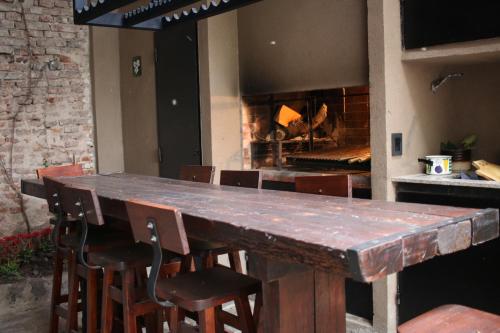 a large wooden table with chairs and a fireplace at LA CASITA in Buenos Aires