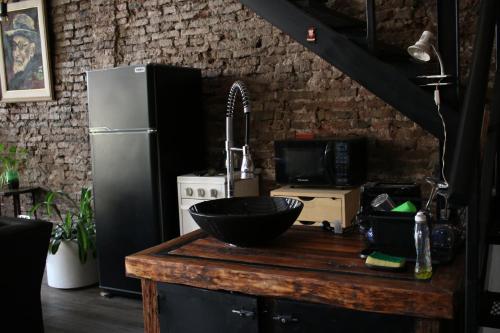 a kitchen with a counter with a sink and a refrigerator at LA CASITA in Buenos Aires