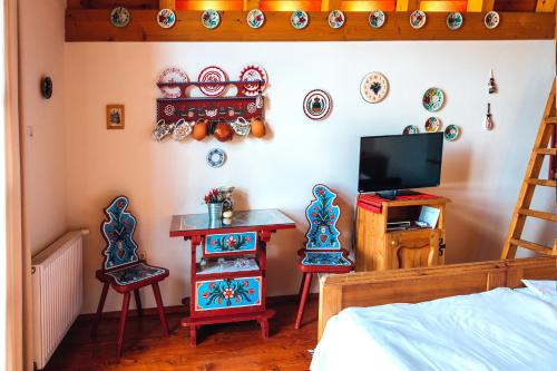 a bedroom with two chairs and a table and a television at Bagoly Pincesor Fogado in Pécs