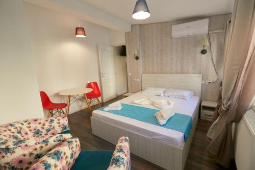 1 dormitorio con 1 cama, 1 silla y 1 mesa en Stanford Aparthotel en Bucarest