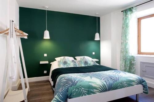 - une chambre avec un mur vert et un lit dans l'établissement Les Gîtes de Laure - L'Or Vert, Appartement avec Vue sur le Château, Parking Privé, Climatisation, Netflix, à 160 m de la Cité Médiévale, à Carcassonne