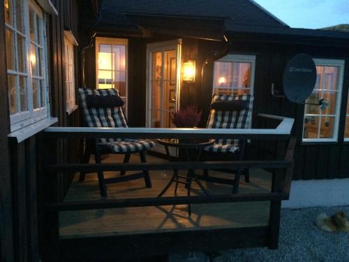 two chairs sitting on the porch of a house at Veslehytta - cabin 1050 moh via amazing view and ambiance in Ål