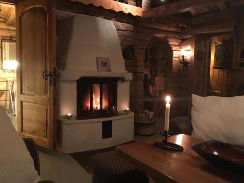 a fireplace in a room with a table and a candle at Veslehytta - cabin 1050 moh via amazing view and ambiance in Ål