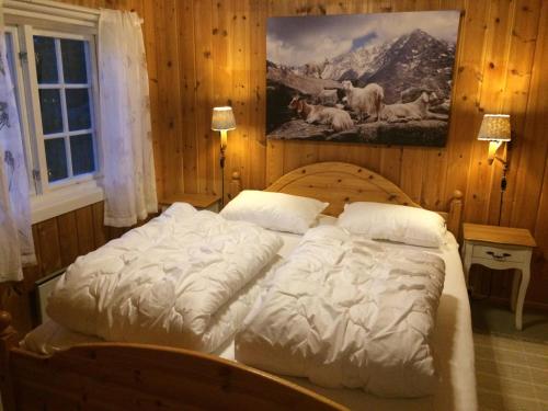 two beds in a bedroom with a painting on the wall at Veslehytta - cabin 1050 moh via amazing view and ambiance in Ål