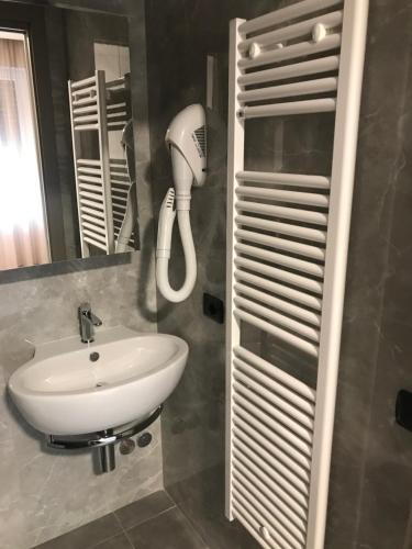 een badkamer met een wastafel en een haardroger bij Albergo RISTORANTE SOTTOCASTELLO in Cassacco