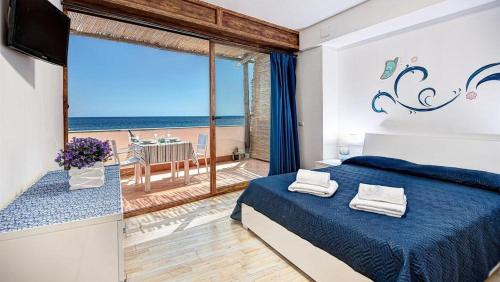 1 dormitorio con cama y vistas al océano en Belmare Residence on the beach en Nerano