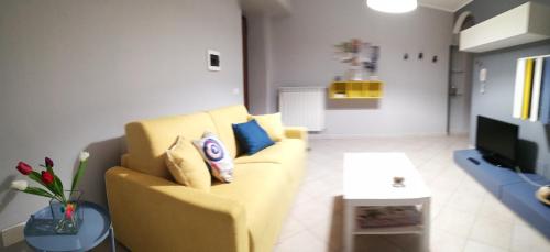 uma sala de estar com um sofá amarelo e uma televisão em Anchida casa vacanze em Enna