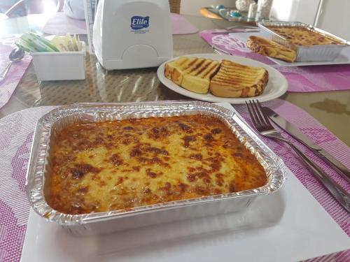a casserole in a pan on a table with plates of food at Hotel Mare Mare Inn in San Andrés