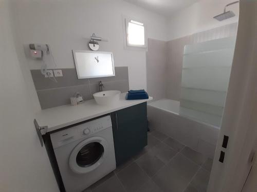 a bathroom with a washing machine and a sink at COSYLOC studios in Cergy