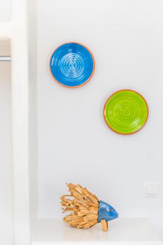 three different colored plates on a white wall at Harmony Luxury Villas Naxos in Naxos Chora