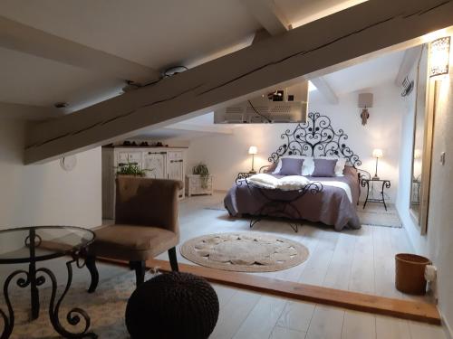 une chambre avec un lit, une chaise et une table dans l'établissement LES CHAMBRES MANON - Piscine, Spa, Tennis, à Belcodène