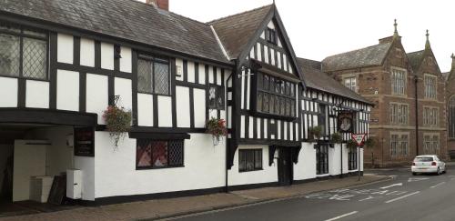 a row of black and white buildings on a street at Queens Head Inn in Monmouth