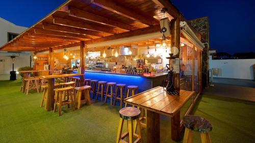 a bar with wooden stools and a bar with a kitchen at FBC Fortuny Resort - Adults Only in Maspalomas